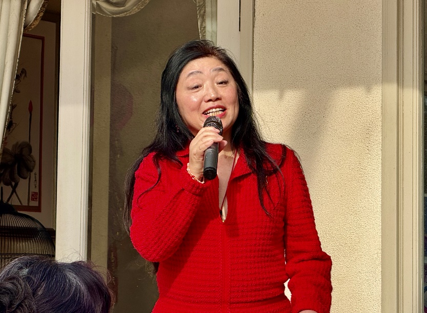 A person in a red dress holding a microphone

Description automatically generated